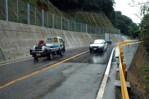 開通した災害現場を通行する車両