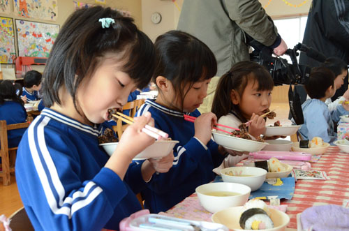 鯨の竜田揚げを食べる園児たち