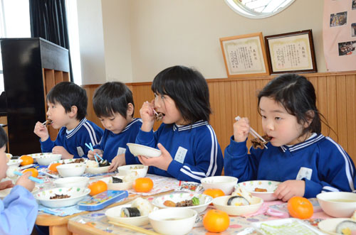 鯨の竜田揚げを食べる園児たち