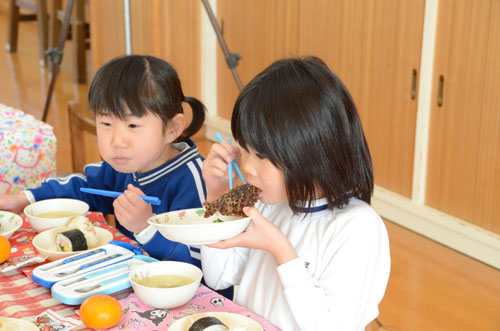 鯨の竜田揚げを食べる園児たち