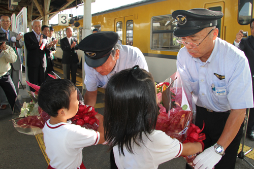 保育園児から運転手に花束が手渡されるところ