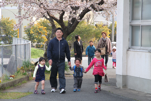 手をつないで登園する園児