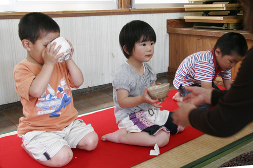 作法を学びながら丁寧にお茶を飲む園児