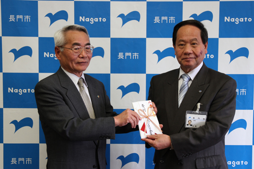 藤井理事長から寄付金が手渡された