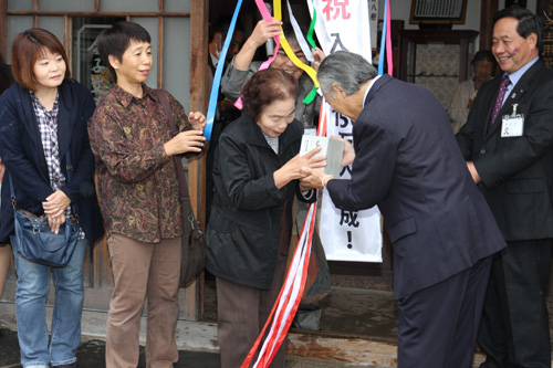 お母さんの里子さんが矢崎館長からみすゞの全集を贈られる