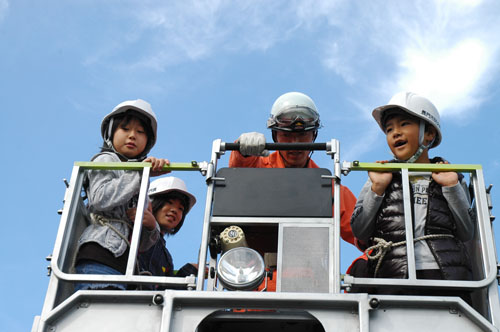 消防梯子車に乗って喜ぶ子どもたち