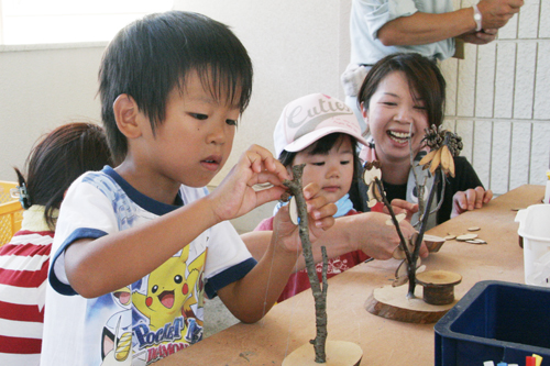 慎重に木工クラフトをつくる子ども