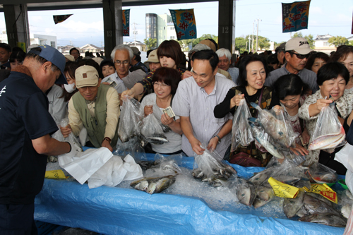 販売開始と同時に、新鮮なとれたての魚を買い求める