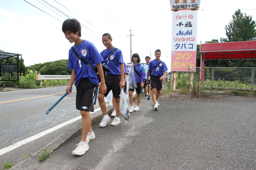 歩道を歩きながらごみを拾う