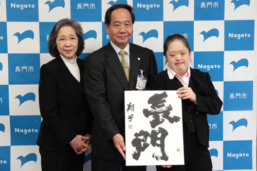 「長門」と書かれた書を手に記念撮影