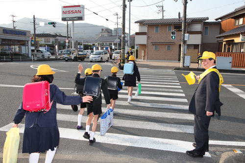 児童が横断歩道を歩くのを見守る大西市長