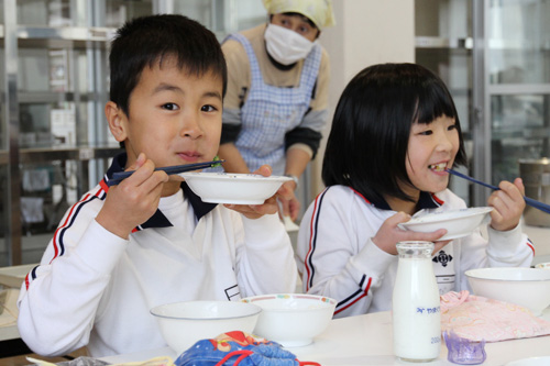 おいしそうに給食を食べる児童