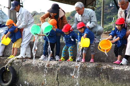 「大きくなってね」と稚魚を放流