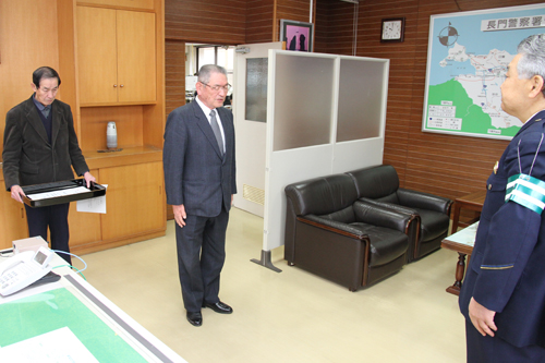 楠長門警察署長に報告する谷川会長（中央）