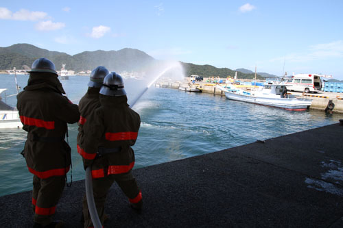 海水を使って炎上する漁船を消化する消防隊員