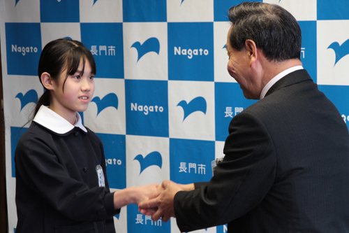 激励費を受け取り握手を交わす平岡さん
