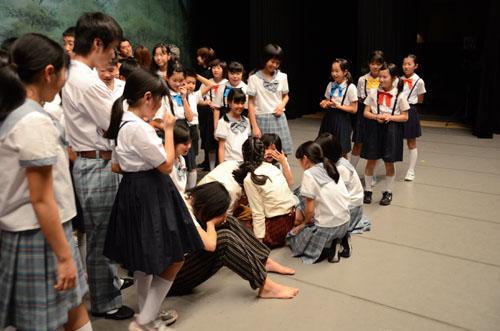 幕が降りてステージに座り込む子どもたち