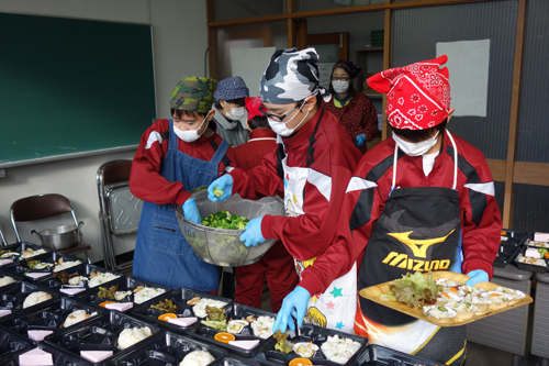 中学生が盛りつけを手伝う