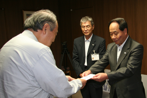 大西市長から野村萩市長に募金が手渡される