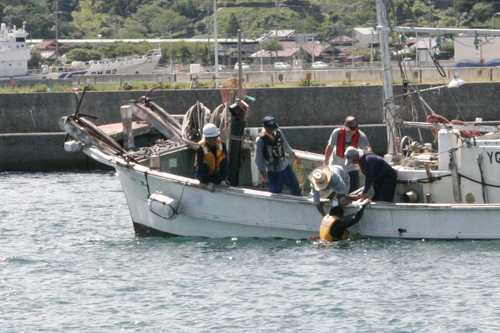 海中転落者を救助船に引き上げるところ