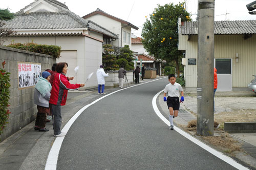 手製の横断幕と旗で応援する地区住民の皆さん