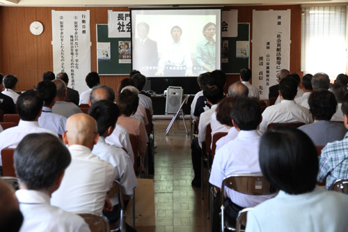 ビデオを視聴する約90人の出席者
