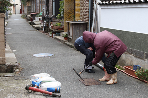 消火栓のふたを開ける自主防災組織の住民