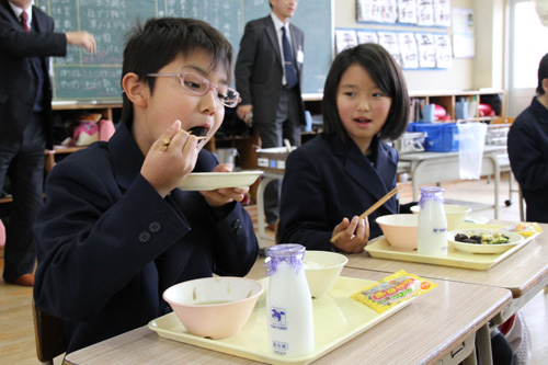 竜田揚げを食べる児童