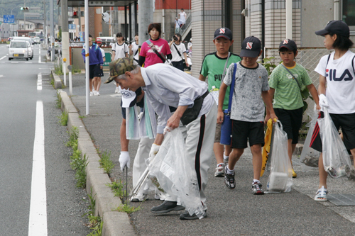 ゴミを集めながら道路沿いを歩く参加者