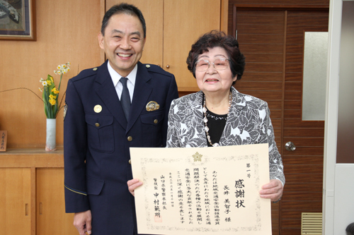 感謝状を受けた長井さん（右）と濱池長門警察署長