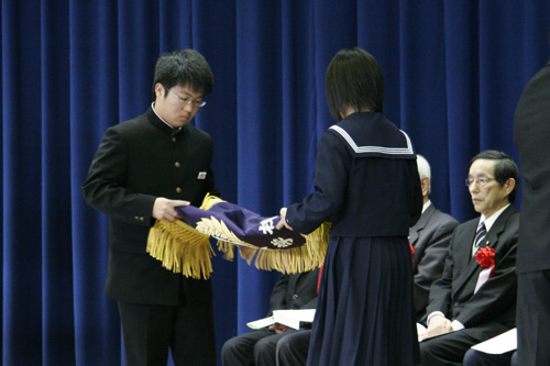 校旗を折りたたむ在校生