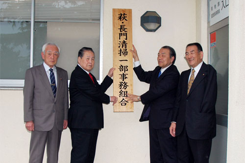 看板を掲げる両市長、両脇は両市の市議会議長