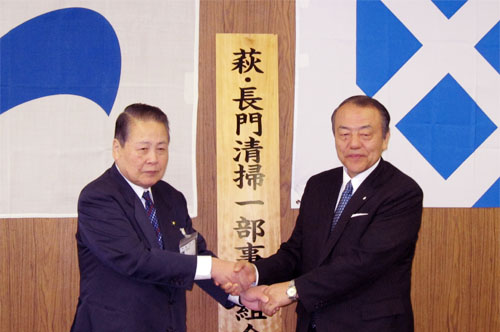 看板の前で握手をする両市長