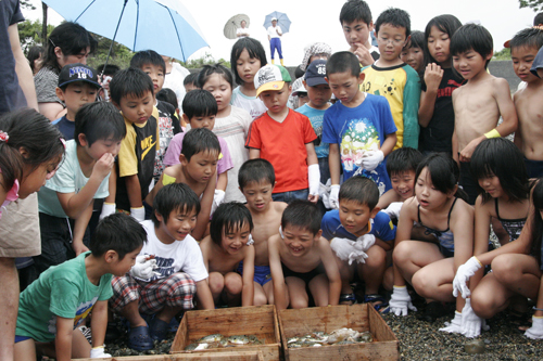 獲れた魚を見つめる子どもたち