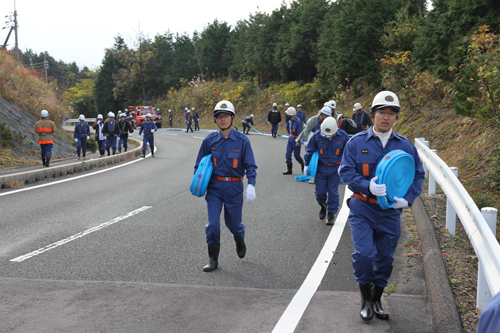 上り坂をホースを抱えて延長