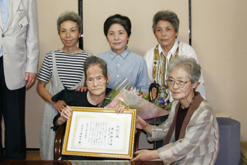 娘たちに囲まれて記念撮影する木村鈴子さん
