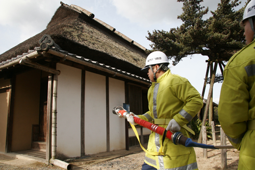 三隅山荘前でホースを構える消防団員