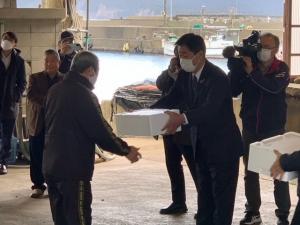 市長が漁業者へアワビの種苗を手渡す様子