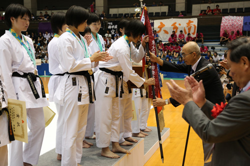 優勝旗を受け取る女子団体組手優勝の日本航空高校