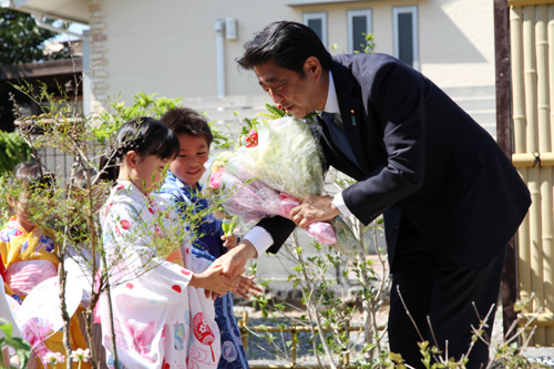 園児から花束を受け取り握手を交わす