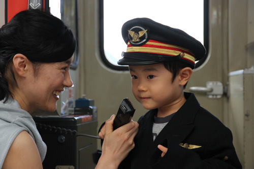 子ども用の制服を着て車掌体験