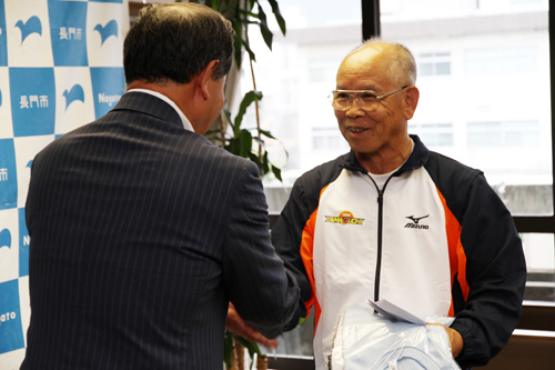 激励費とTシャツが手渡された後、大西市長と固い握手