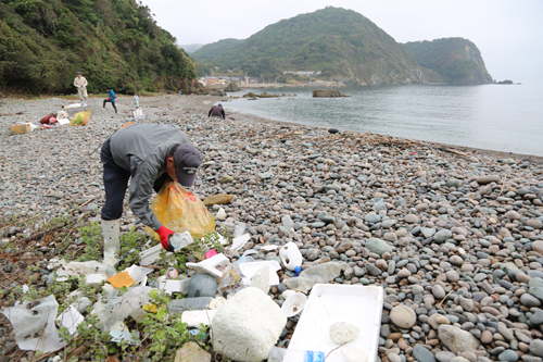 海岸に流れ着いたごみを集める