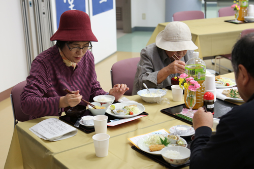 海の幸がふんだんに使われた定食を味わう来場者
