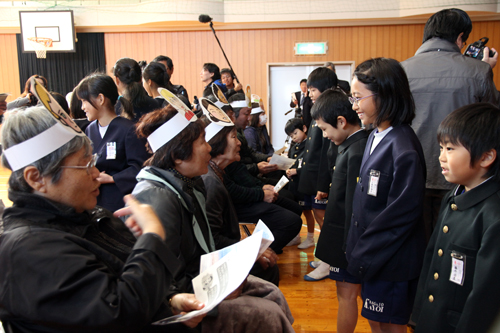 お面をかぶった外国人役の人に通地区の良さを伝える実習