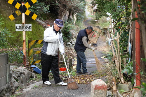 道路上の落ち葉を掃く