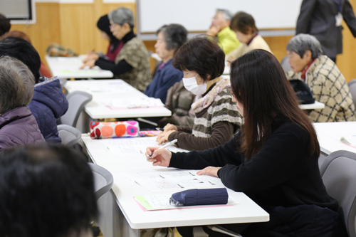メモを取りながら講演を聴く参加者