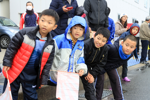 沿道でランナーの到着を待つ子どもたち