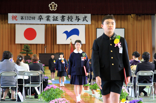 拍手に送られて会場を後にする卒業生