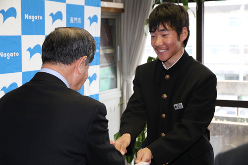キャプテンの植村さんに激励費を手渡し、握手を交わす
